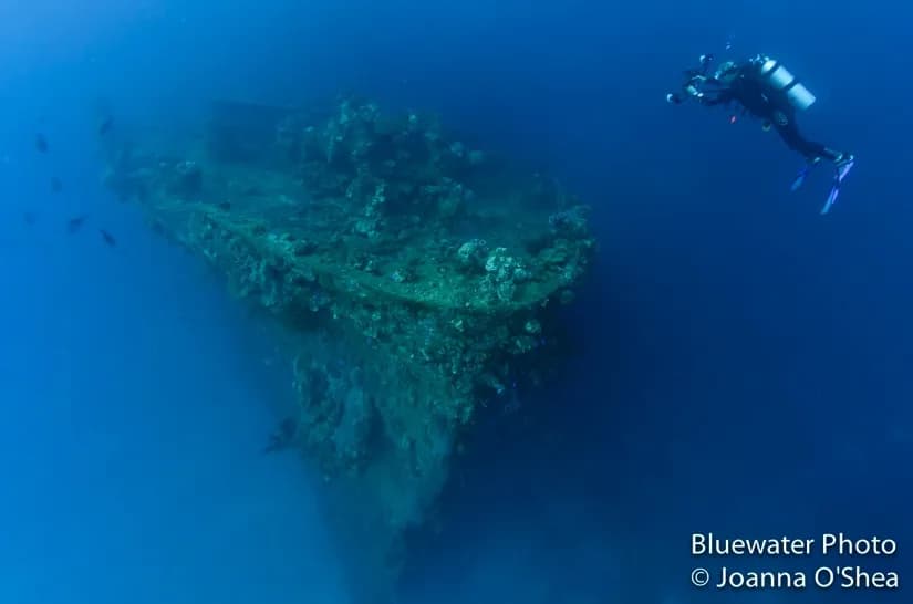 Scuba diver photographing a ship wreck underwater in truk lagoon micronesia