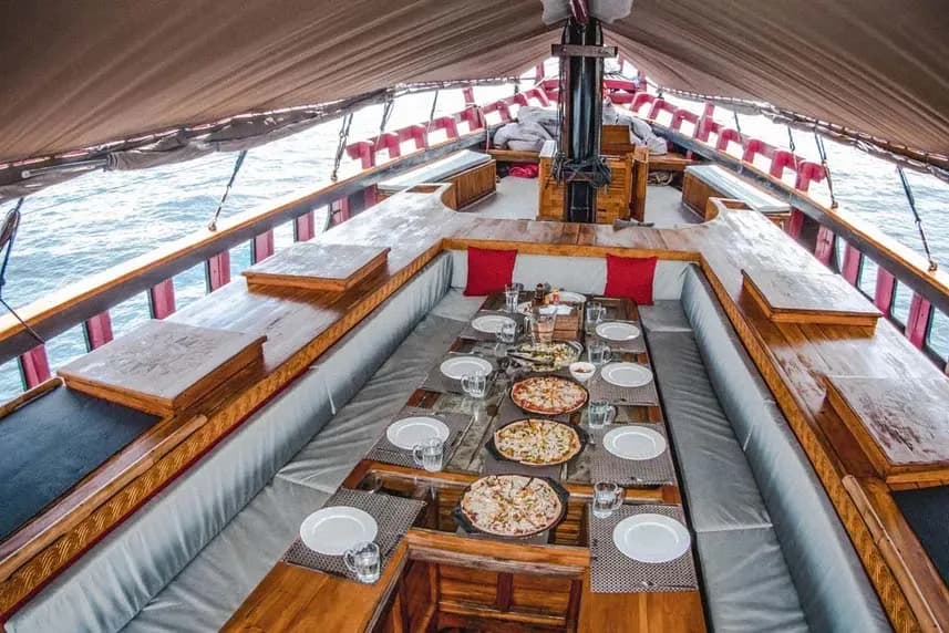 Dining room on the Calico Jack boat featuring a table and chairs, set for a cozy meal with a view of the water.