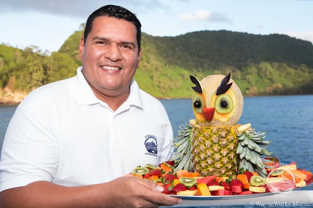 an Oceanic Aggressor II crew member holds a colorful drink.