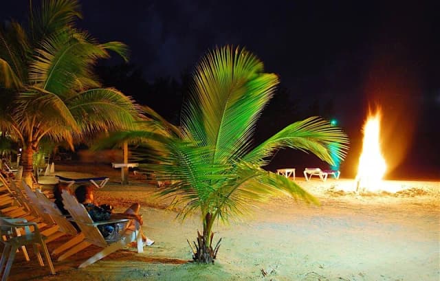 A fire on a beach at Fantasy Island Roatan Resort.
