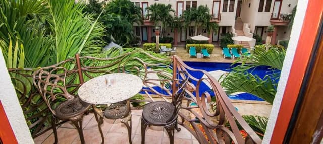 A balcony with table and chairs at Las Sirenas by Mayan Princess Roatan
