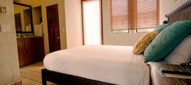 A bed in a deluxe room at Las Sirenas by Mayan Princess Roatan