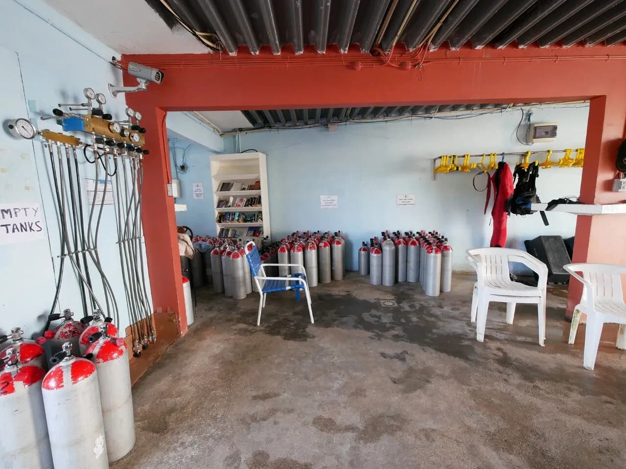 A room filled with scuba tanks and chairs, ready for diving adventures and relaxation.