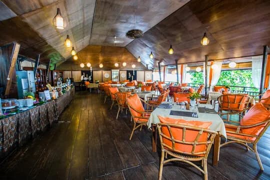 Tables and chairs in a restaurant with a long buffet table Tables and chairs in a restaurant with a long buffet table