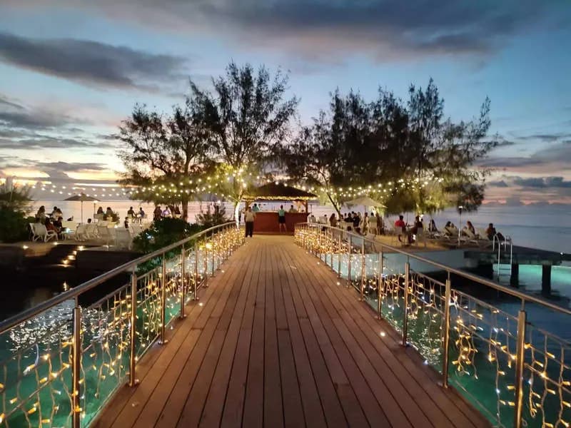 An over-water walkway adorned with strings of lights at Te Moana Tahiti Resort An over-water walkway adorned with strings of lights at Te Moana Tahiti Resort