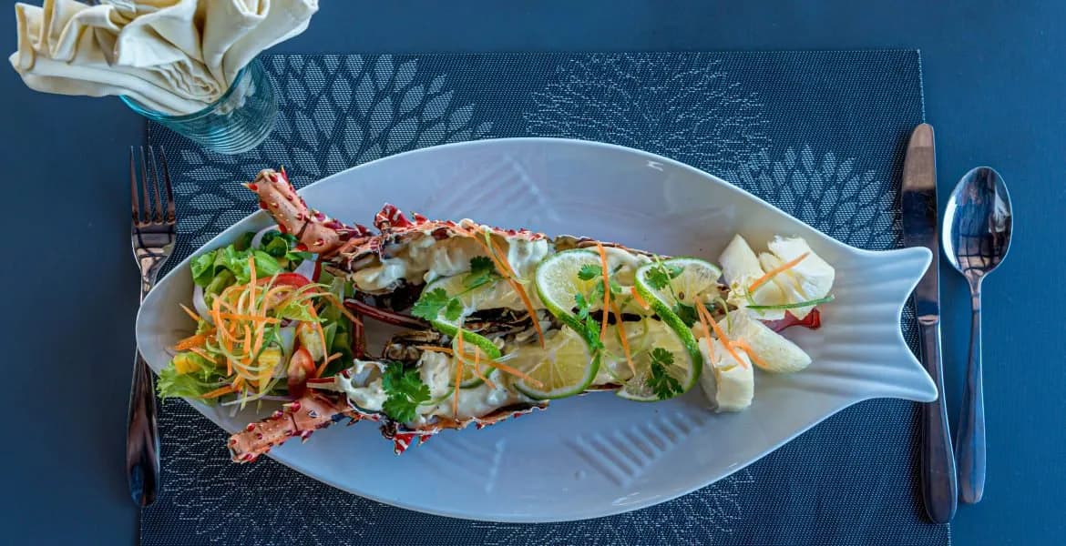 Delicious meal laid atop a fish-shaped plate Delicious meal laid atop a fish-shaped plate