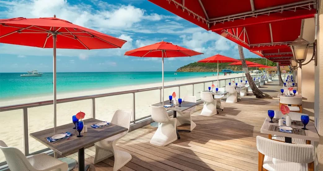 Dining chairs and tables set up by the beach Dining chairs and tables set up by the beach
