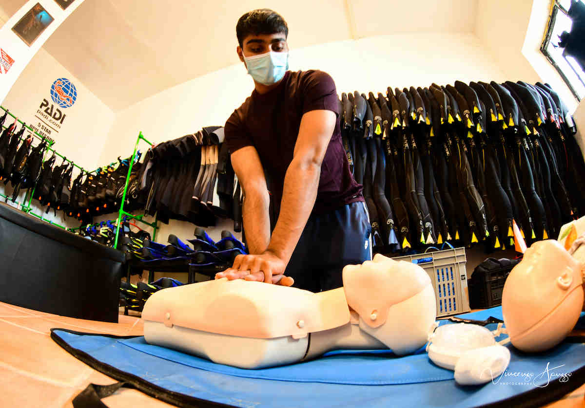 An instructor performs cpr on a dummy