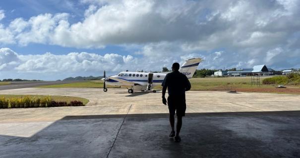 A man walks toward a prop plane to travel to Yap Island.