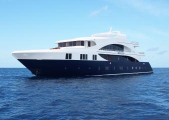 A luxurious yacht, the MV Emperor Serenity Liveaboard, sailing gracefully in the vast ocean of the Maldives.