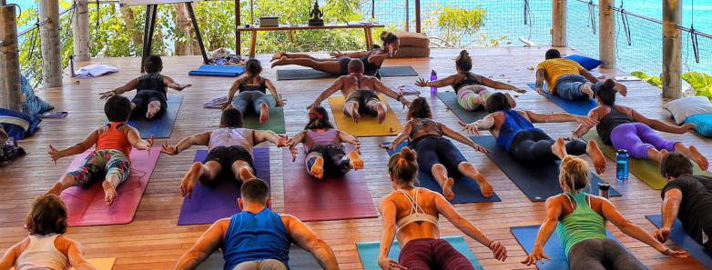 A group of people do yoga at Bloo Lagoon Eco Village