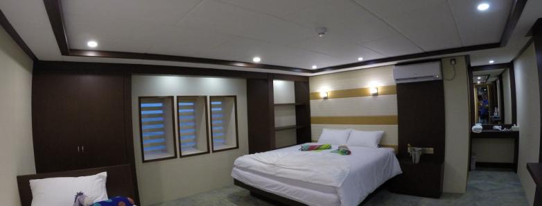 Luxurious cabin on the MV Emperor Serenity Liveaboard, Maldives, with twin beds and a TV.