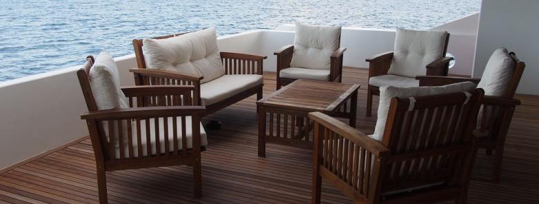 Wooden deck with tables and chairs on MV Emperor Serenity Liveaboard in the Maldives.