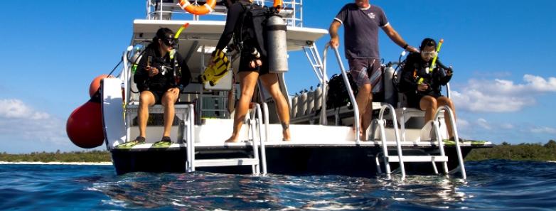 Scuba divers prepare to enter the water at Little Cayman Beach Resort