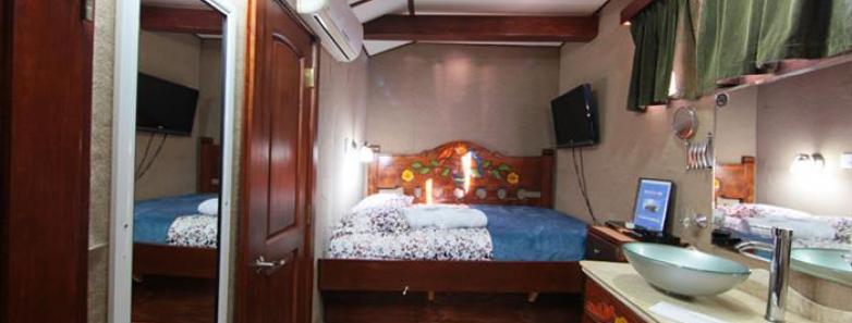 Interior of the MV Valentina double cabin with double bed, TV, and vanity.
