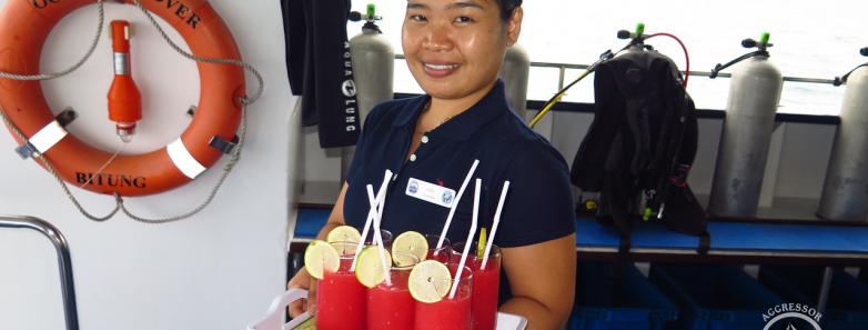 A crew member holds a tray of fruit juice on the Raja Ampat Aggressor 