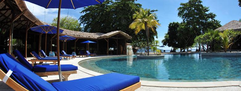 Swimming pool and lounge chairs at Siladen Resort & Spa Bunaken