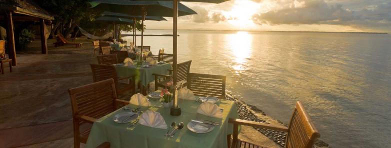 An outdoor restaurant with a sunset view at Toberua Island Resort Fiji.