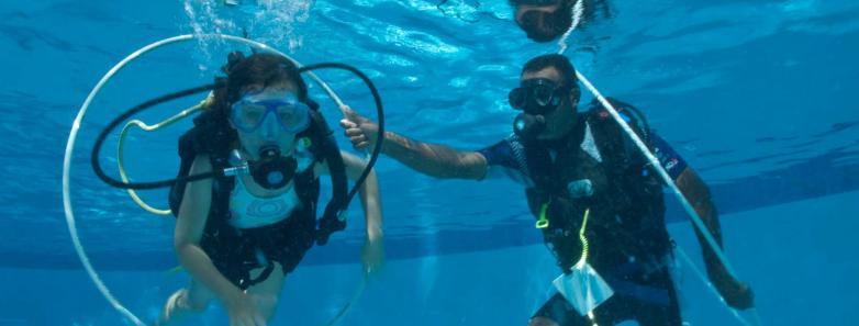 A scuba diver performs buoyancy exercises with an instructor at Toberua Island Resort Fiji.