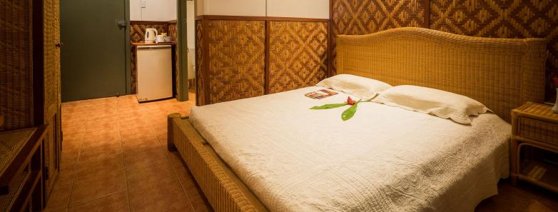 A bed in a deluxe room at Tufi Resort Papua New Guinea