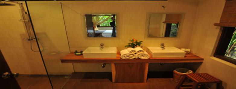 A double vanity and a shower in a deluxe bungalow bathroom at Watergarden Resort Bali.