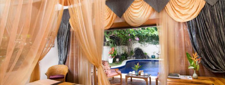 A Kul Kul suite bed looks onto a pool at Watergarden Resort Bali.