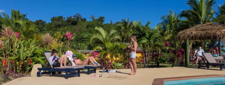 People interact next to the pool at Waidroka Bay Resort