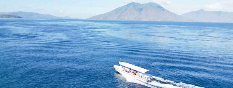 A dive boat cruises through the Pandar Strait at Alor Tanapi Dive Resort.