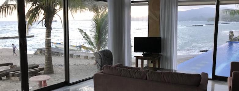A lounge area looks onto the beach and sea at Bayshore Villas Candidasa.