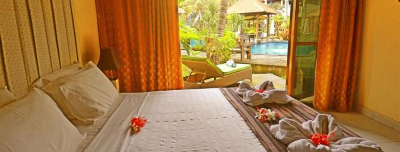 A large bed in a pool view bungalow at Bayshore Villas Candidasa.