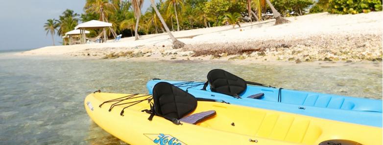 Two kayaks sit in the water next to the beach at Cayman Brac Beach Resort