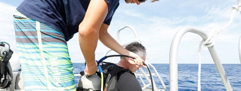 A scuba diver prepares their equipment at Cayman Brac Beach Resort