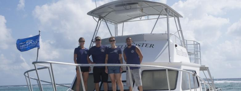 The crew pose on the bow of the dive boat at Cayman Brac Beach Resort