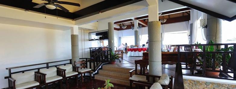 Enjoy the charm of a large restaurant with wooden floors and a ceiling fan at Crystal Blue Resort in Anilao, Philippines