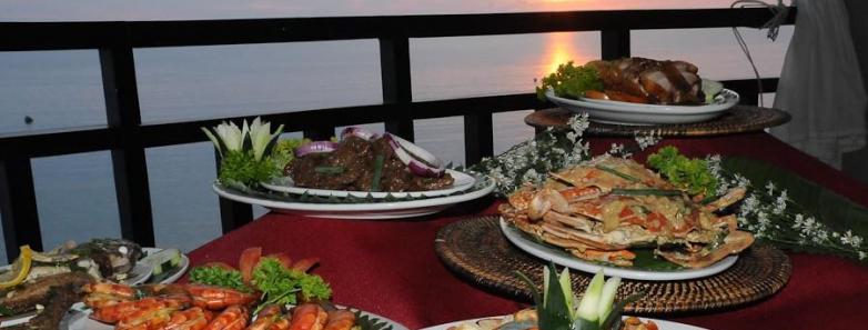 Platters of food adorn a table overlooking the ocean at Crystal Blue Resort, Anilao.