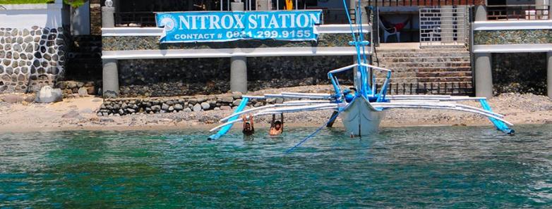 A dive shop nestled on the shore of crystal blue waters at Crystal Blue Resort in Anilao, Philippines.