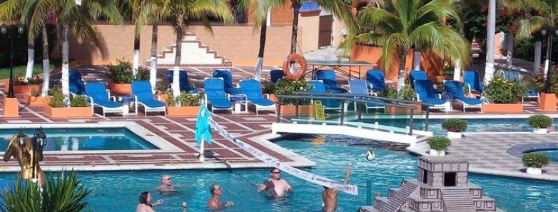 People compete in a game of volleyball in the pool at Cozumel Palace.