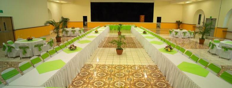 A grand banquet hall with elegant green and white table cloths, ready to host a memorable event.
