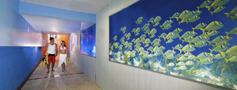 A hallway with blue walls and a blue fish painting.