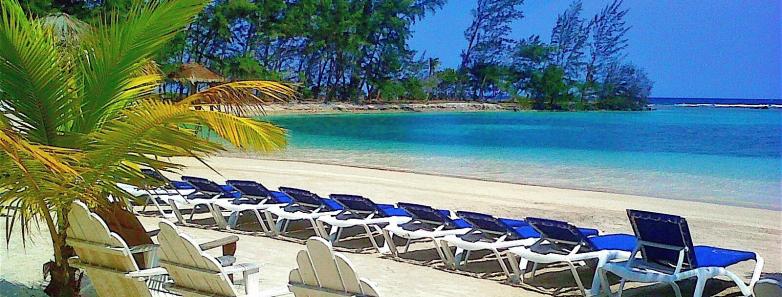 A row of beach chairs at Fantasy Island Roatan Resort.
