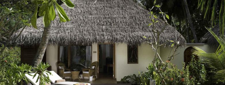 A deluxe beach villa is nestled in the jungle at Kuramathi Island Resort Maldives.