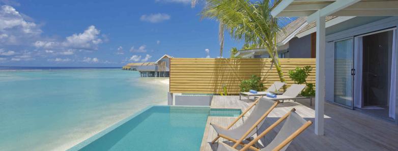A pool next to the sea stretches the length of a pool villa at Kuramathi Island Resort Maldives.