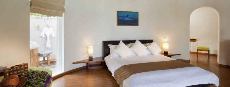 The modern bedroom of a superior beach villa at Kuramathi Island Resort Maldives.