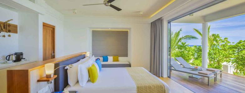 A bright and modern bedroom in a two bedroom beach house at Kuramathi Island Resort Maldives.