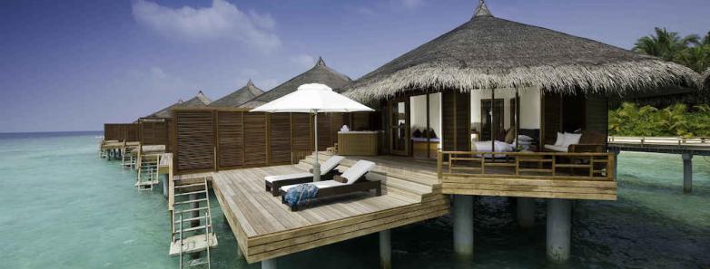 A water villa sits perched above the turquoise sea at Kuramathi Island Resort Maldives.