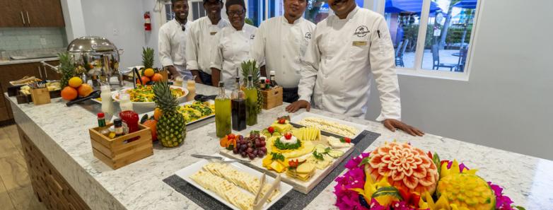 Chefs pose with food at Little Cayman Beach Resort