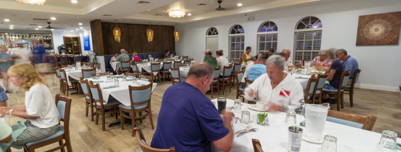 People enjoy a meal in the dining room at Little Cayman Beach Resort