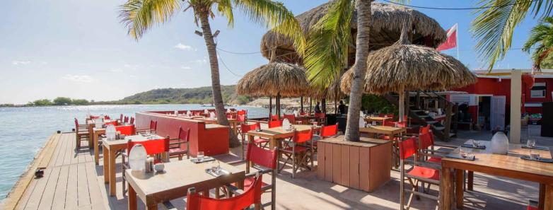 Tables at a seaside restaurant at Livingstone Jan Thiel Beach Resort