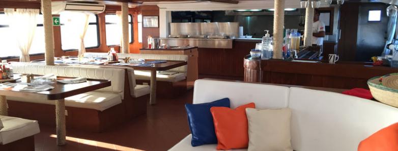 Dining room interior with the galley in the background aboard the MV Valentina liveaboard.
