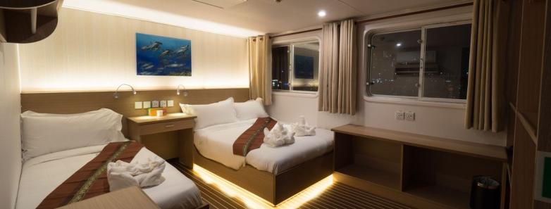Interior view of the White Manta liveaboard combined double-twin cabin